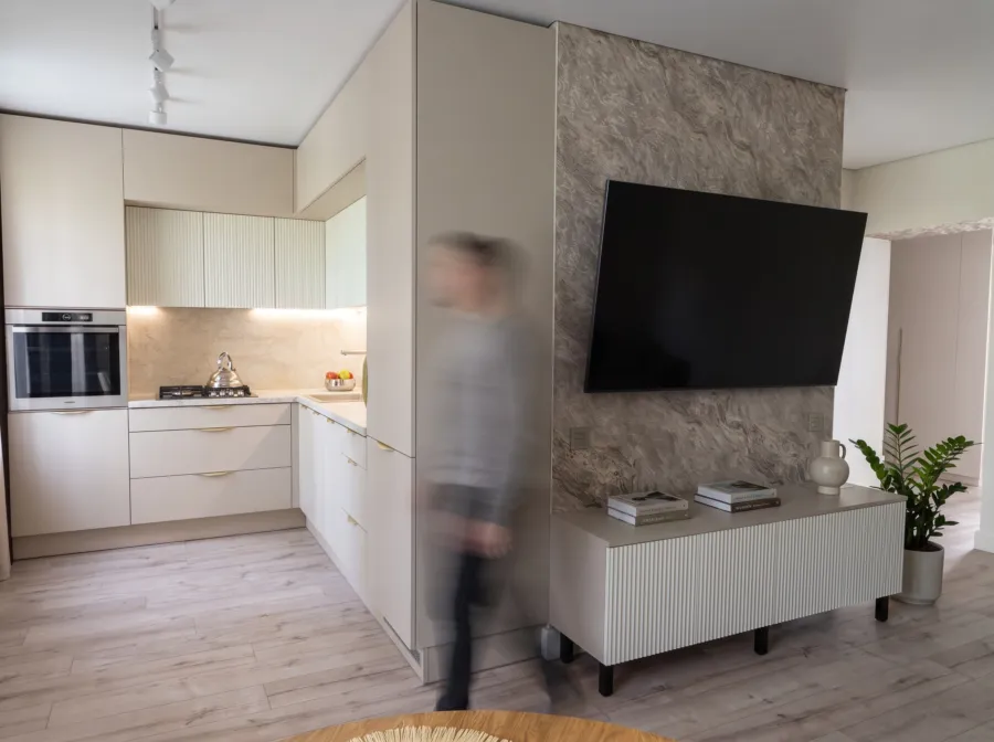 Avatud köök-elutuba: beež köök ja madal TV-kapp