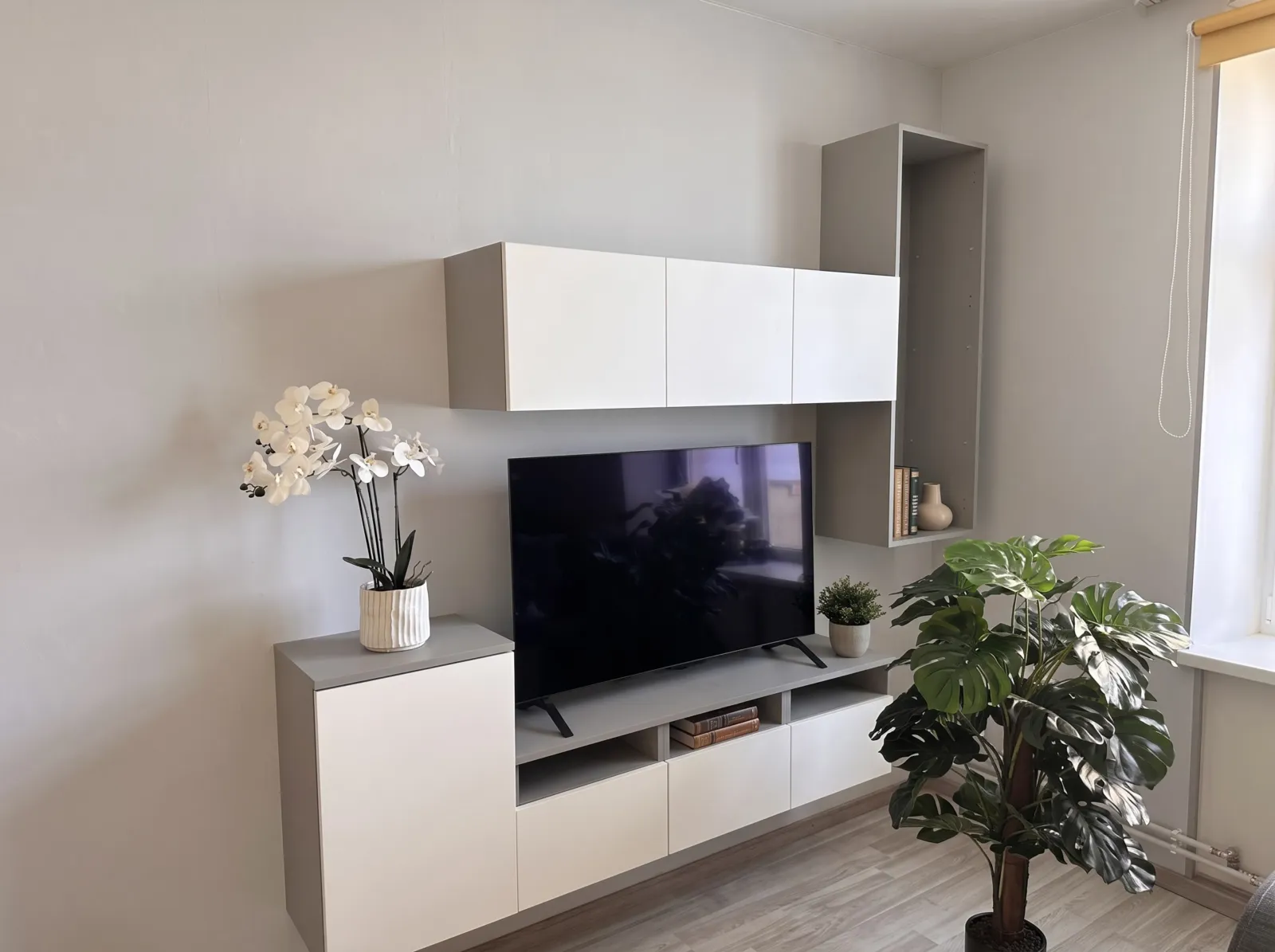 Valge-hall TV-sein rippuvate kappide ja madala TV-kapiga